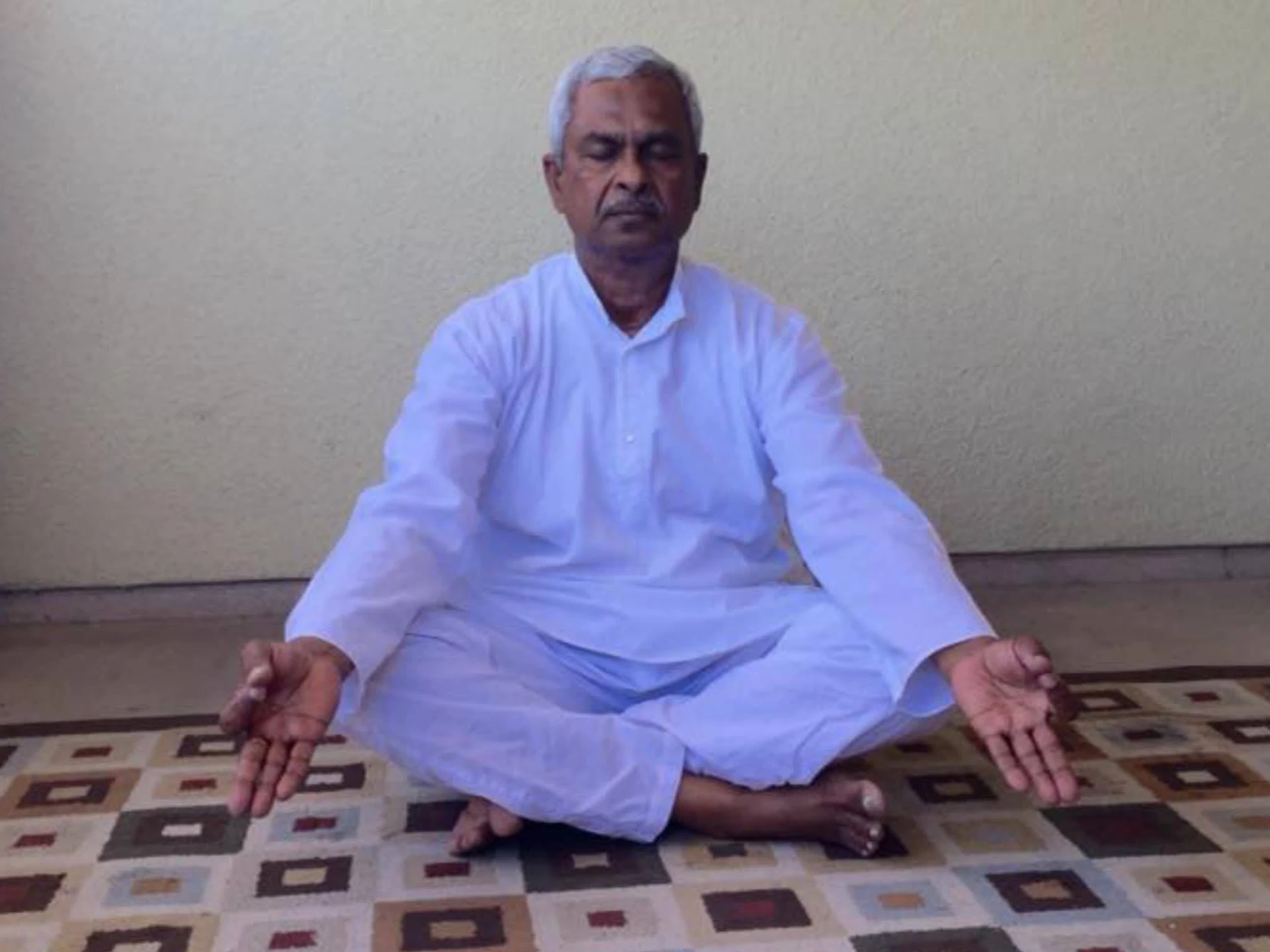 Gangadhara Tilak Katnam seated cross-legged with eyes closed — one of the rare moments he sat still